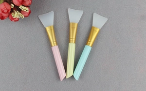 Three silicone face mask brushes with pastel handles and soft white application tips
