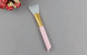 Detail shot of the soft white silicone brush head and pink handle for smooth face mask application