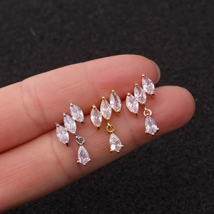 Three zircon flower stud earrings in silver, gold, and rose gold finishes on a finger