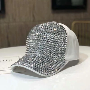 Dettaglio degli strass argentati scintillanti sulla superficie del berretto da baseball bianco