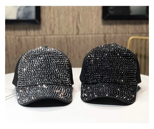 Dettaglio di cappellini da baseball neri e argento decorati con strass scintillanti