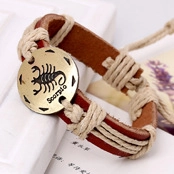 Detail view of leather bracelet featuring a metal Scorpio charm and braided cords