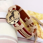 Macro view of vintage brown braided leather bracelet with Capricorn bronze metal charm