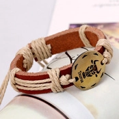 Macro detail of Taurus zodiac charm on brown braided leather and hemp rope bracelet