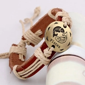 Detail of woven leather bracelet featuring a bronze Pisces zodiac charm and hemp rope