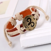 Close-up of woven leather Aries zodiac bracelet with engraved bronze charm on frame