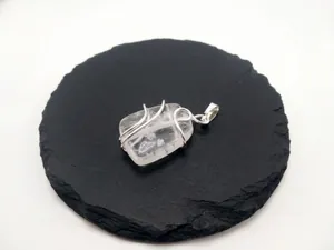 Natural clear quartz pendant with handmade silver wire wrapping on black stone