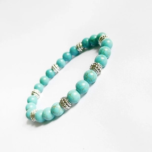 8mm turquoise bead stretch bracelet with silver-tone decorative metal spacers on white background