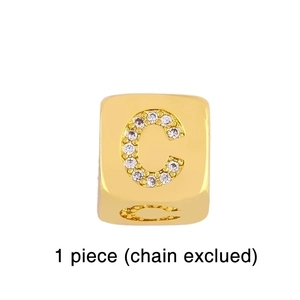 Macro detail of gold plated square bead with cubic zirconia letter C inlay charm