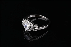 Detail of silver heart-shaped ring featuring infinity symbols and sparkling zircon stones