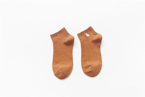 Detail shot of brown cotton blend sock featuring white alpaca embroidery on the ankle cuff