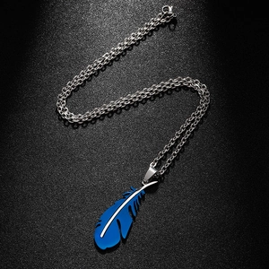 Detailed close-up of a blue feather pendant on a polished stainless steel link chain