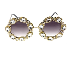 Detail of oversized gold sunglasses with purple gradient lenses and crystal rhinestones