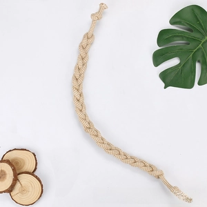 Detail of durable hand-woven cotton dog rope toy with natural wood and leaf accents