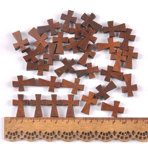 Brown wooden cross beads for DIY jewelry making shown with a measuring scale