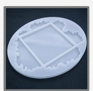 Detailed view of an oval wave-patterned silicone mold for DIY resin coasters on a black surface