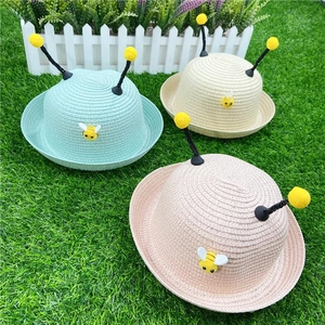 Detail of woven straw children's sun hats with cute bee embroidery and antenna decor