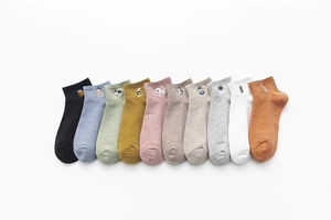 Detail view of ten colorful cotton socks with cute animal embroidery on white background