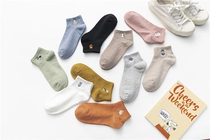 Flat lay of colorful cotton socks featuring delicate animal embroidery detailing