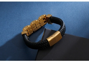 Close-up of black braided leather men's bracelet with polished gold magnetic clasp detail