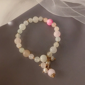 Detailed macro view of strawberry quartz beaded bracelet with pearls and gold charms