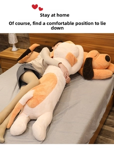 Long puppy plush pillow in beige and orange for side sleeping shown in a bedroom setting