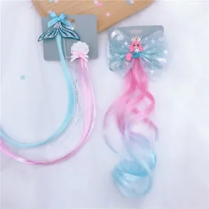 Detail of glitter mermaid tail and bow clips with colorful gradient synthetic hair extensions