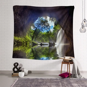 Forest waterfall landscape tapestry displayed in a minimalist room with cozy home decor
