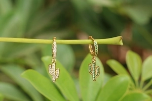 Chic gold cactus drop earrings with green and white zircon crystals on nature branch
