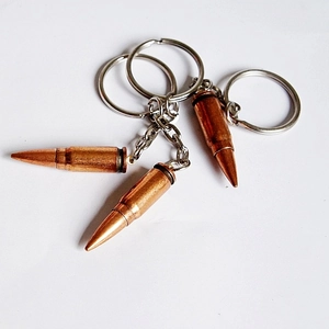 Detailed view of three metal bullet-shaped keychains in bronze and silver finish