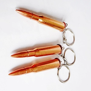 Detailed view of three brass bullet-shaped metal keychains on a white background