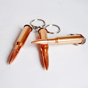 Detailed view of three bronze bullet-shaped metal keychains with silver rings