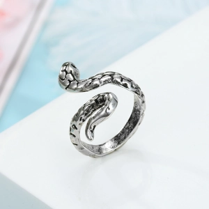 Close-up of vintage silver snake ring with detailed scale texture on white surface