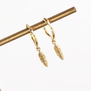 Detailed macro of gold feather pendant hoop earrings with S925 hallmark on white background