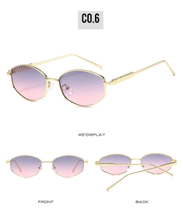 Detail of oval sunglasses with gold frame, purple gradient lenses and wavy temples