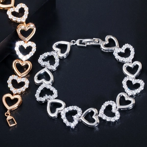 Close-up of hollow heart link bracelets in silver and rose gold with zircon stones