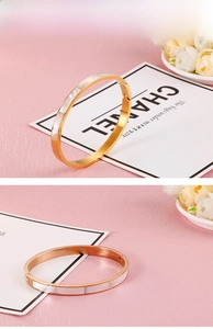 Detail of 6mm gold stainless steel bangle featuring white shell inlay and side hinge
