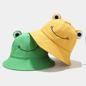 Detail view of cotton bucket hats with 3D eyes and smile embroidery in yellow and green