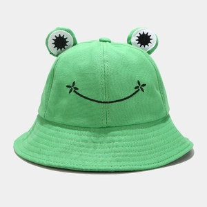 Detailed close-up of green frog bucket hat with 3D eyes and embroidered smile
