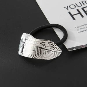 Silver metallic feather hair tie with high-elastic black rope on matte black background