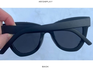 Detail view of black rhinestone cat-eye sunglasses with silver temple accents