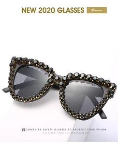 Close-up of luxury cat-eye sunglasses with hand-set black crystals in gold claw mounts
