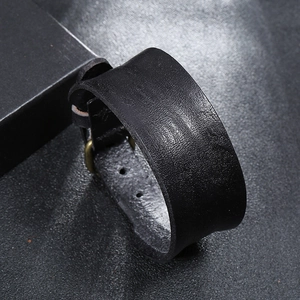 Close-up of black genuine leather wide cuff bracelet with high-quality metal fasteners