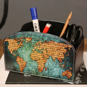 Detail of vintage world map desk organizer holding stationery on a wooden tabletop