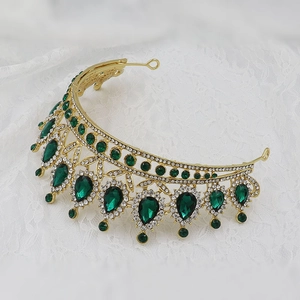 Detail of baroque gold crown with emerald water-drop gems and sparkling crystals