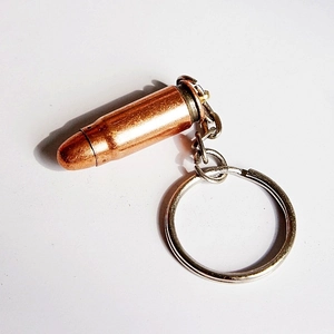 Macro detail of a metal bullet-shaped keychain with realistic copper and silver tones