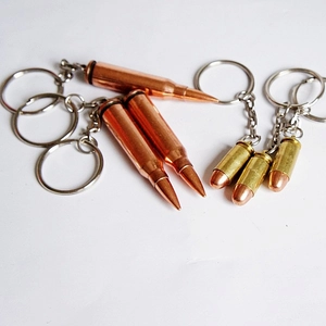 Detailed macro view of heavy metal bullet-shaped keychains in antique bronze and gold finish