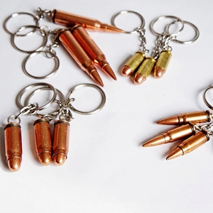 Detailed close-up of bullet-shaped metal keychains in vintage brass and gold tones