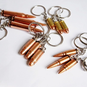 Detailed view of metal bullet-shaped keychains in various sizes, gold and copper finishes