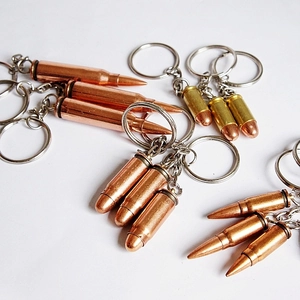 Detailed close-up of metallic bullet-shaped keychains in vintage brass and gold finishes